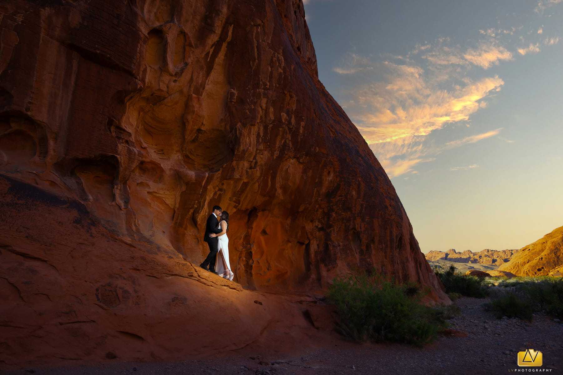 Bride and groom kissing beside a red sandstone cliff at Valley of Fire near Las Vegas