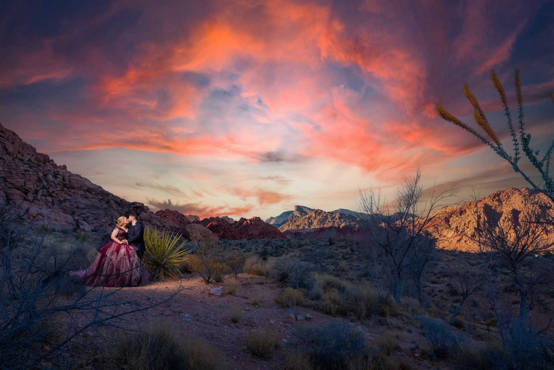 Bride and groom kissing in the desert near Red Spring at Red Rock Canyon with dramatic sunset clouds