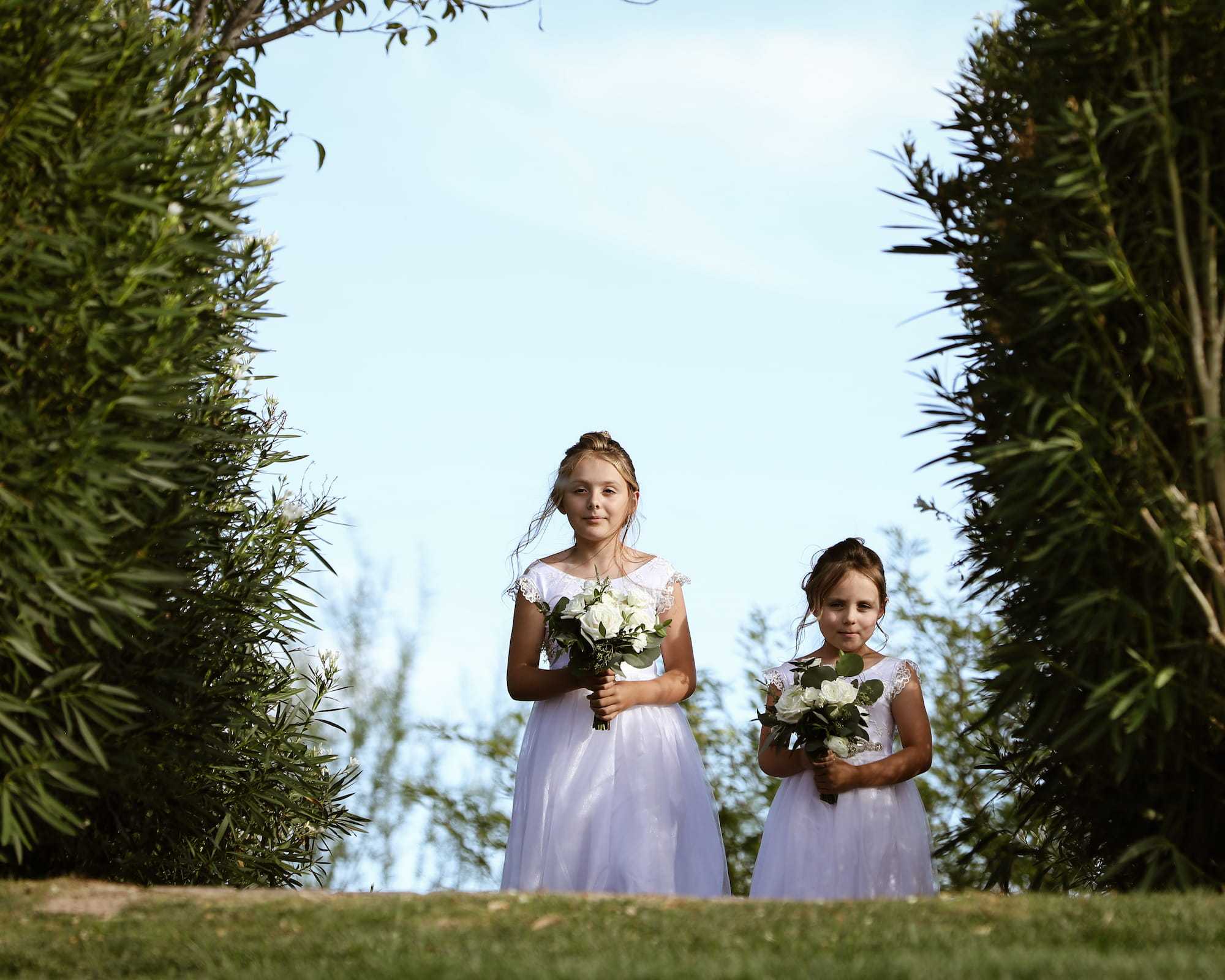 Two flower girls holding bouquets during a wedding at Anthem Country Club in Henderson